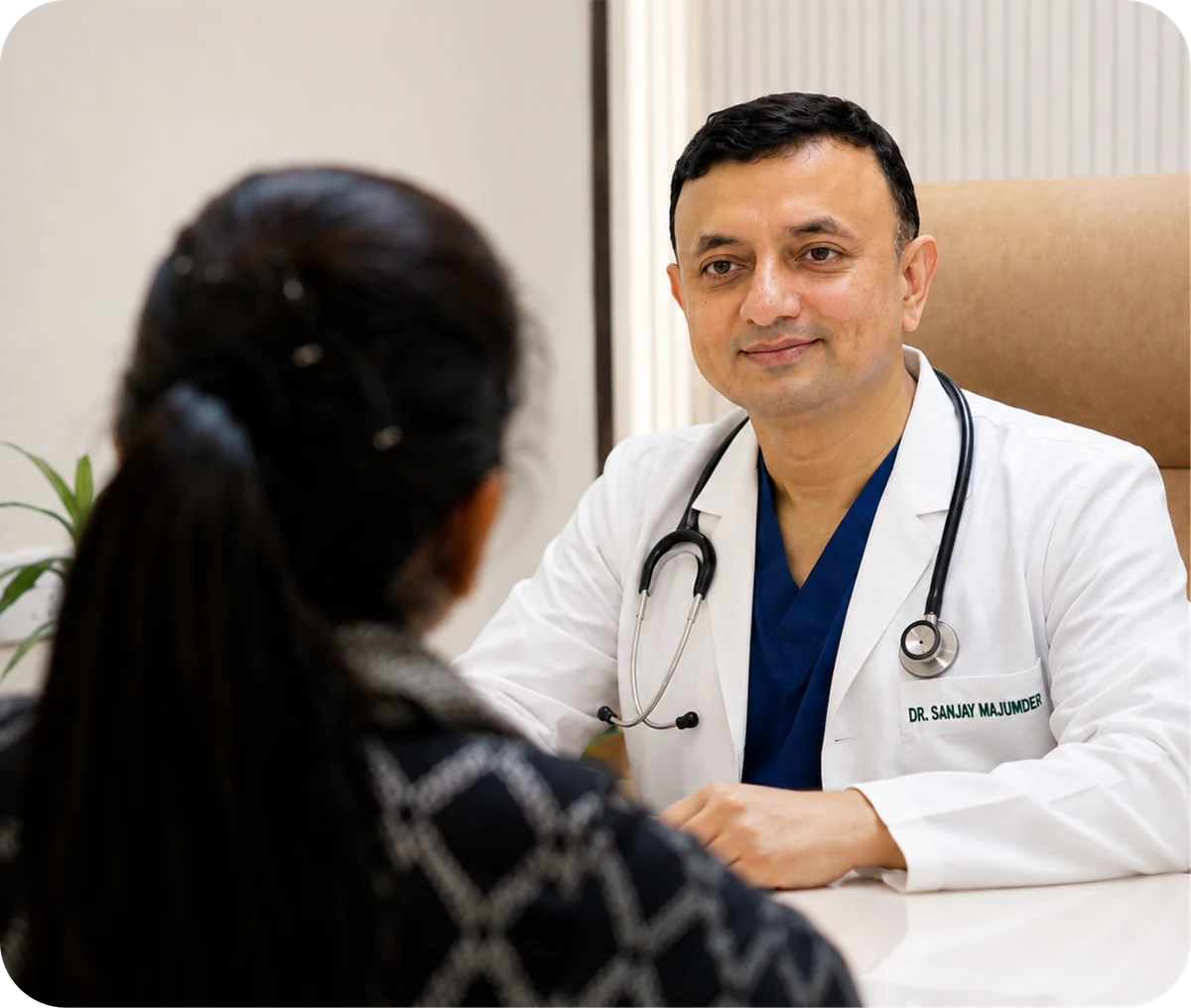 Dr. Sanjay Mazumder listening to a patient during a consultation